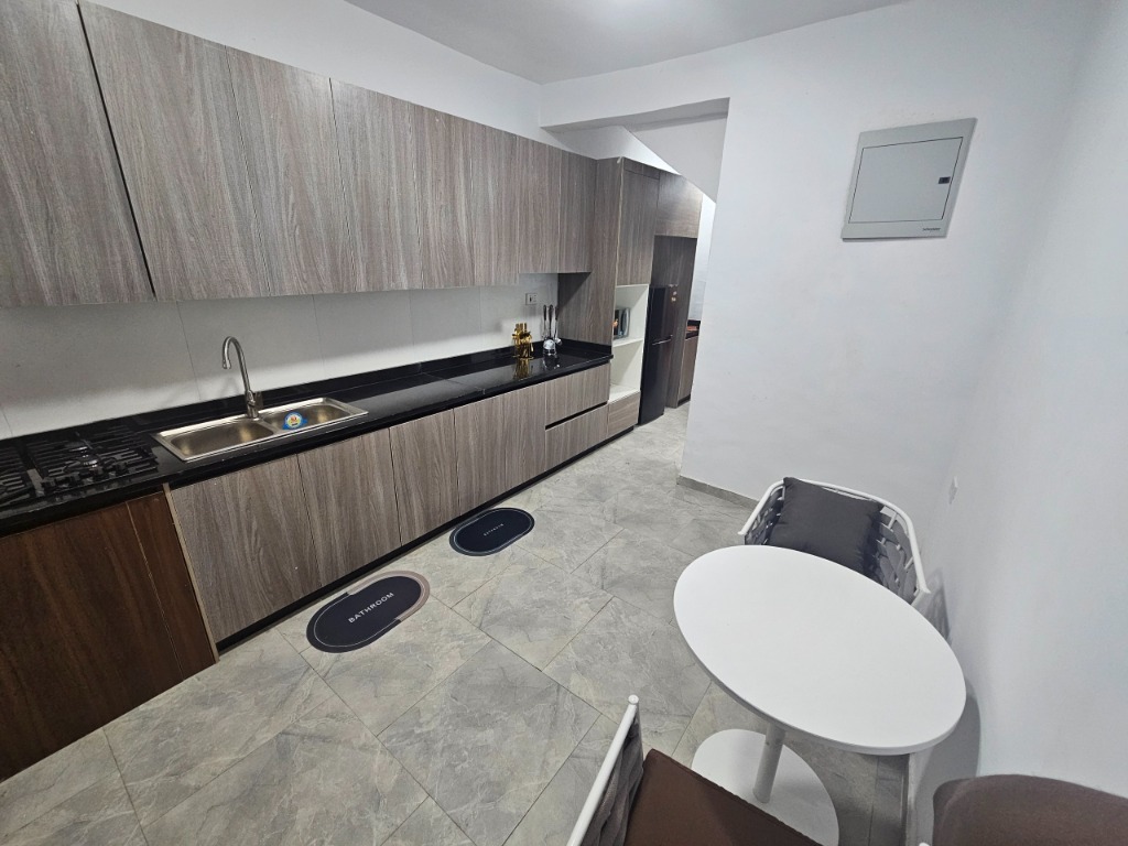 Gourmet kitchen with sleek wood-grain cabinets, dark granite tops, gas cooktop, and breakfast table