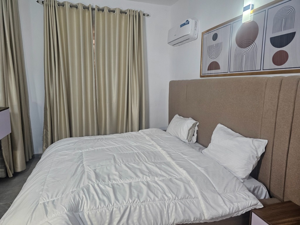 King bed detail with white bedding and air conditioner
